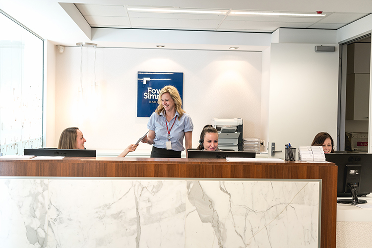 Reception staff assisting patients at the radiology clinic front desk