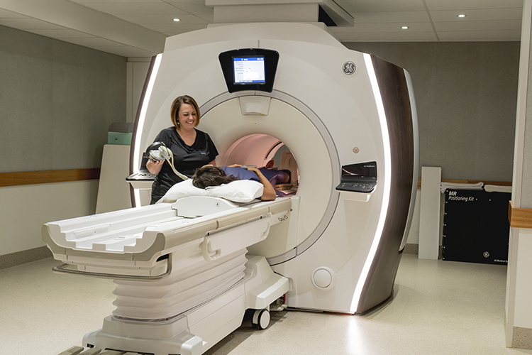 Patient being assisted into an MRI scanner by trained staff
